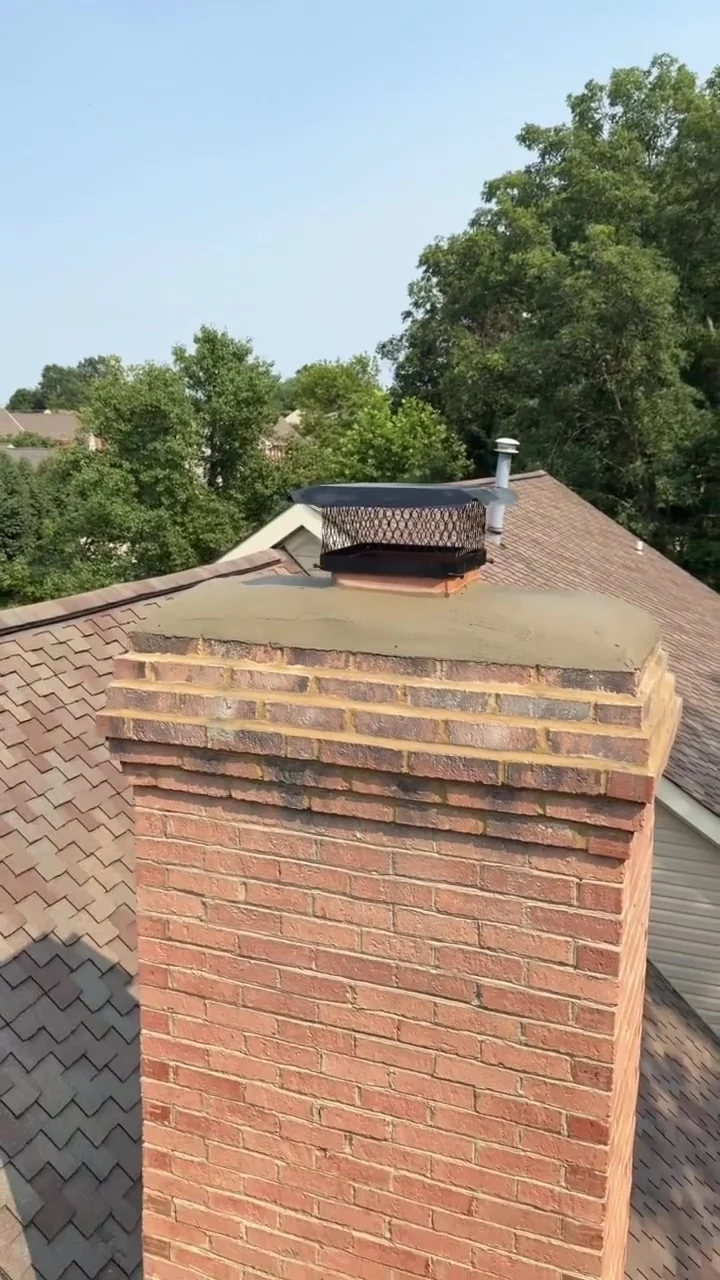 Finished brick chimney crown with a dark protective cap — mobile service overview